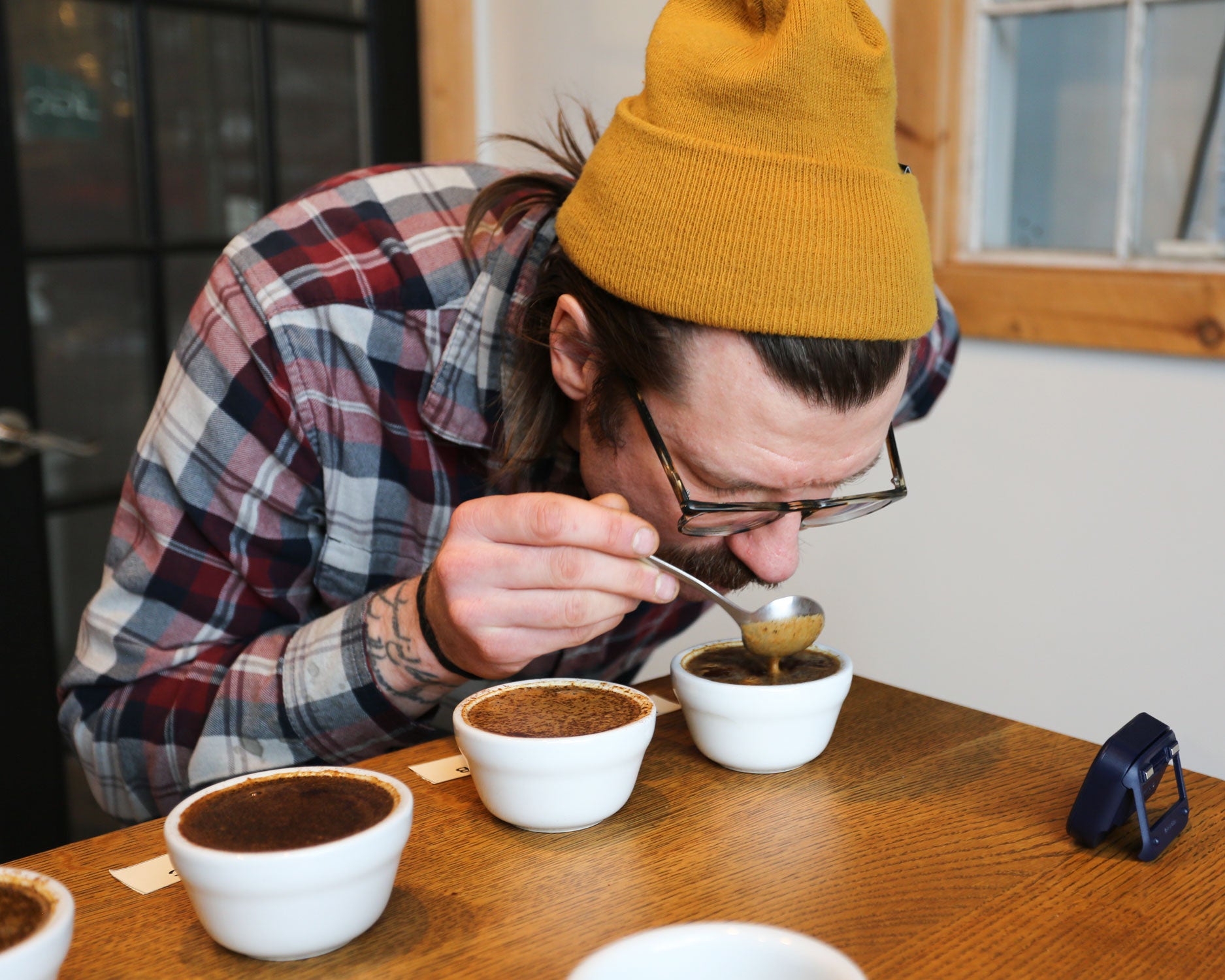 Luke cupping coffee at Tandem Coffee Roaster