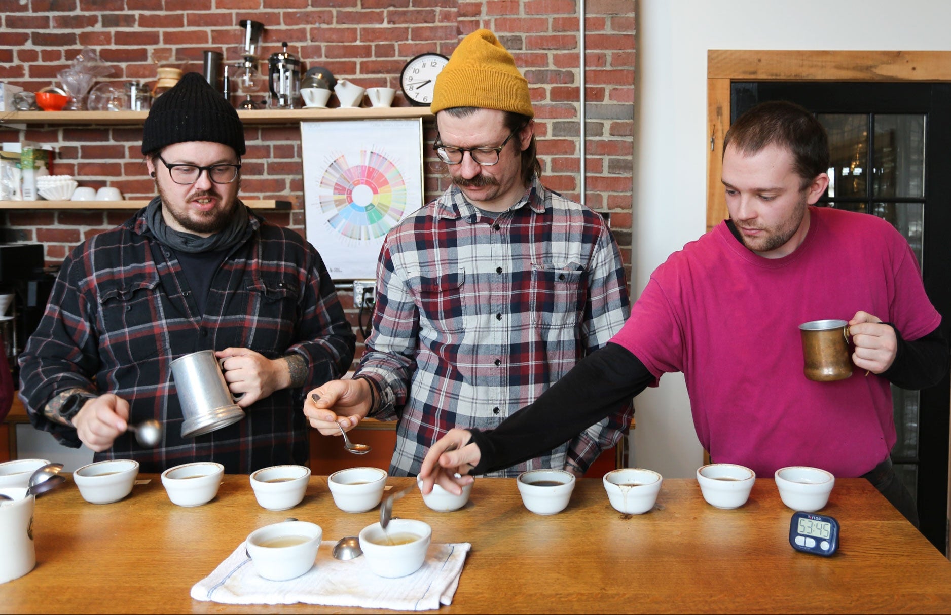 Three folks cupping coffee at the Tandem Coffee Roastery