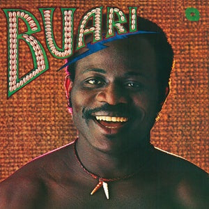 Album cover featuring a smiling man against a textured brown background. At the top, large, stylized text reads "BUARI" in a colorful, beaded design. The man wears a necklace with small beads and a tooth-shaped pendant. This self-titled album by Buari was originally released to showcase his unique style. Brought to you by Tandem Coffee Roasters.