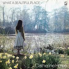 Album cover for "What a Beautiful Place" by Catherine Howe, featuring a woman in a white dress standing by a pond surrounded by daffodils, trees, and serene water on Tandem Coffee Roasters.