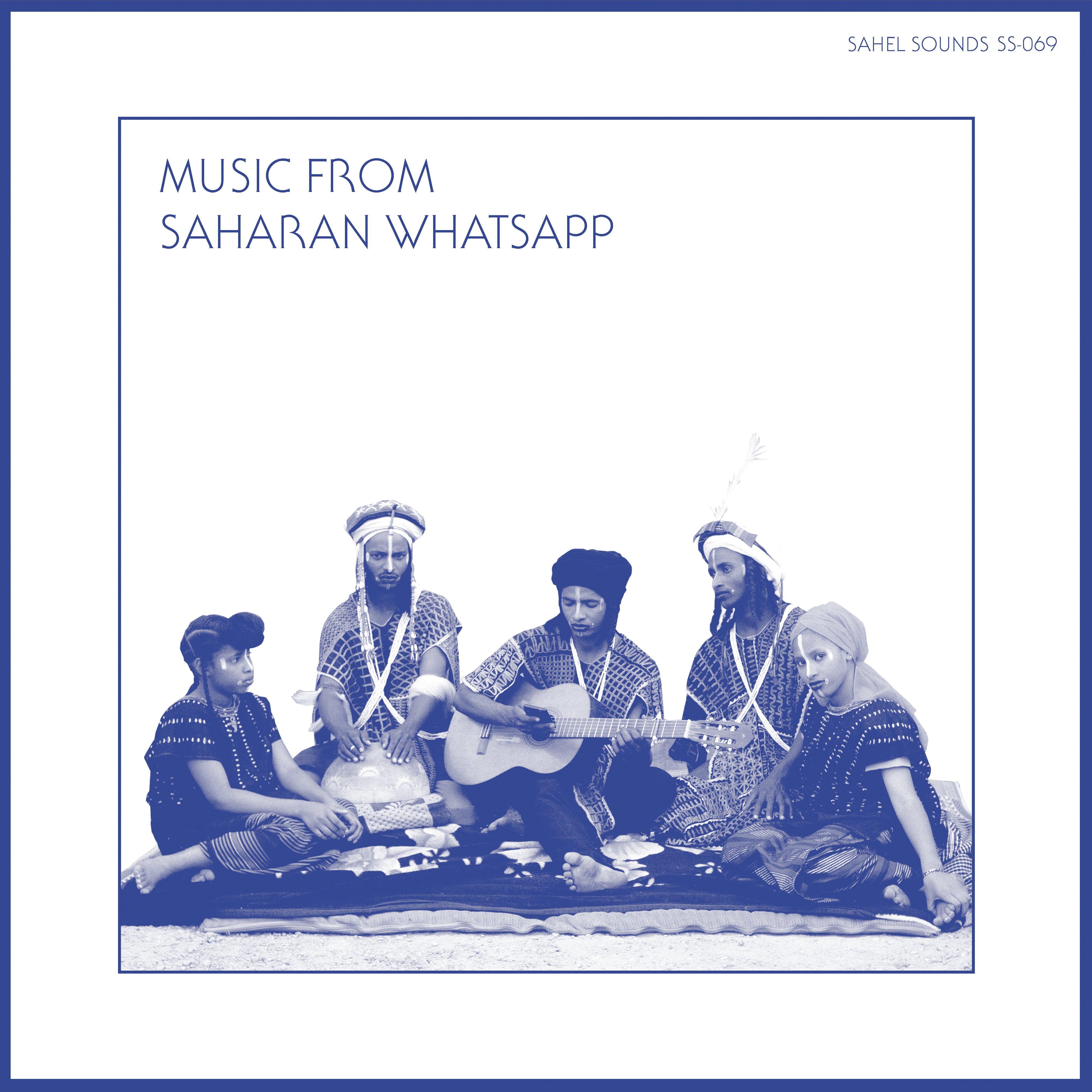 An album cover titled "Music from the Saharan WhatsApp - Various Artists," presented by Tandem Coffee Roasters, features six individuals in traditional attire, seated on a patterned rug. One person is playing an acoustic guitar while the others listen and watch. The minimalist design with a blue border evokes the essence of Luka Productions and Etran de L'Air.